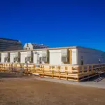 The Exterior of an S-Plex modular building with air conditioning in front of a cityscape or office buildings.