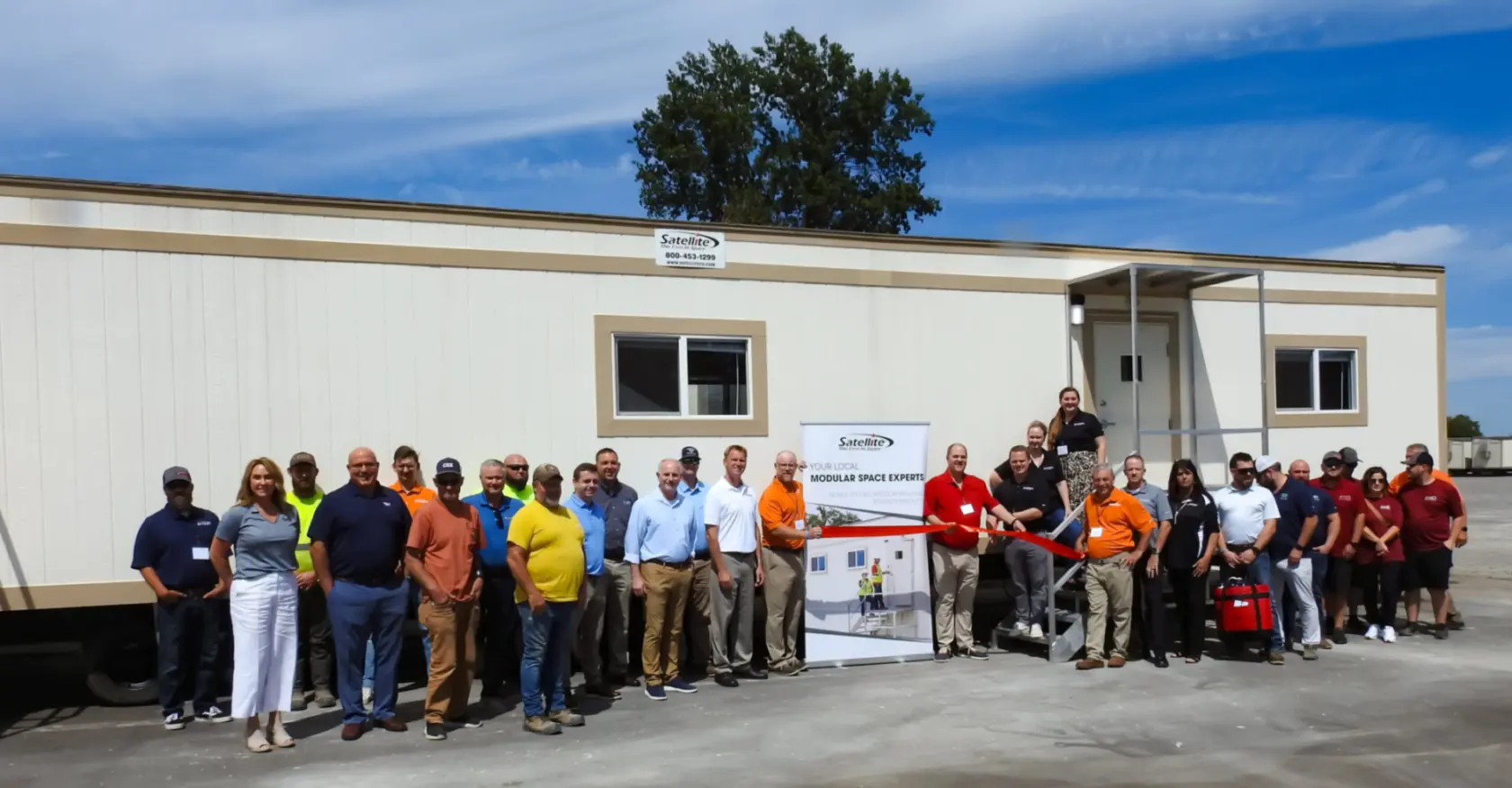 Satellite employees standing in front of new branch location