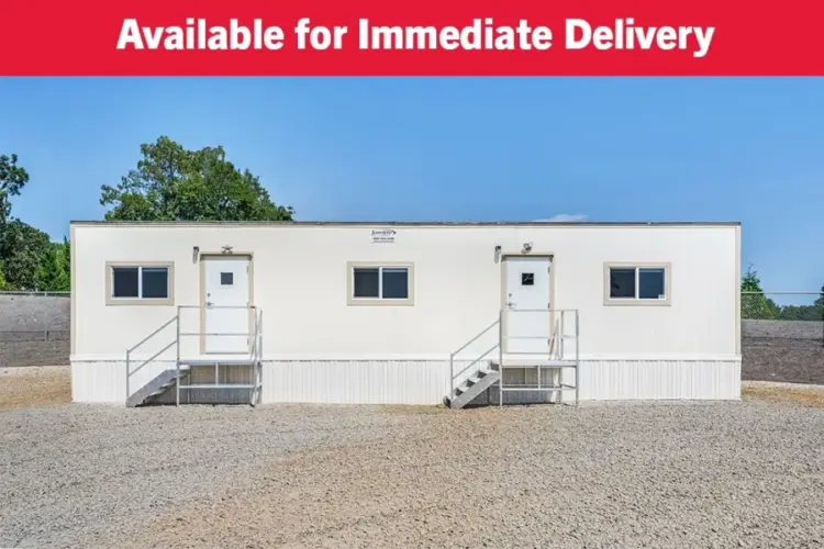 Front view of a 10x50 mobile office. Mobile office has skirting around front of building, 2 exterior doors shown, and steps leading up to the doors.